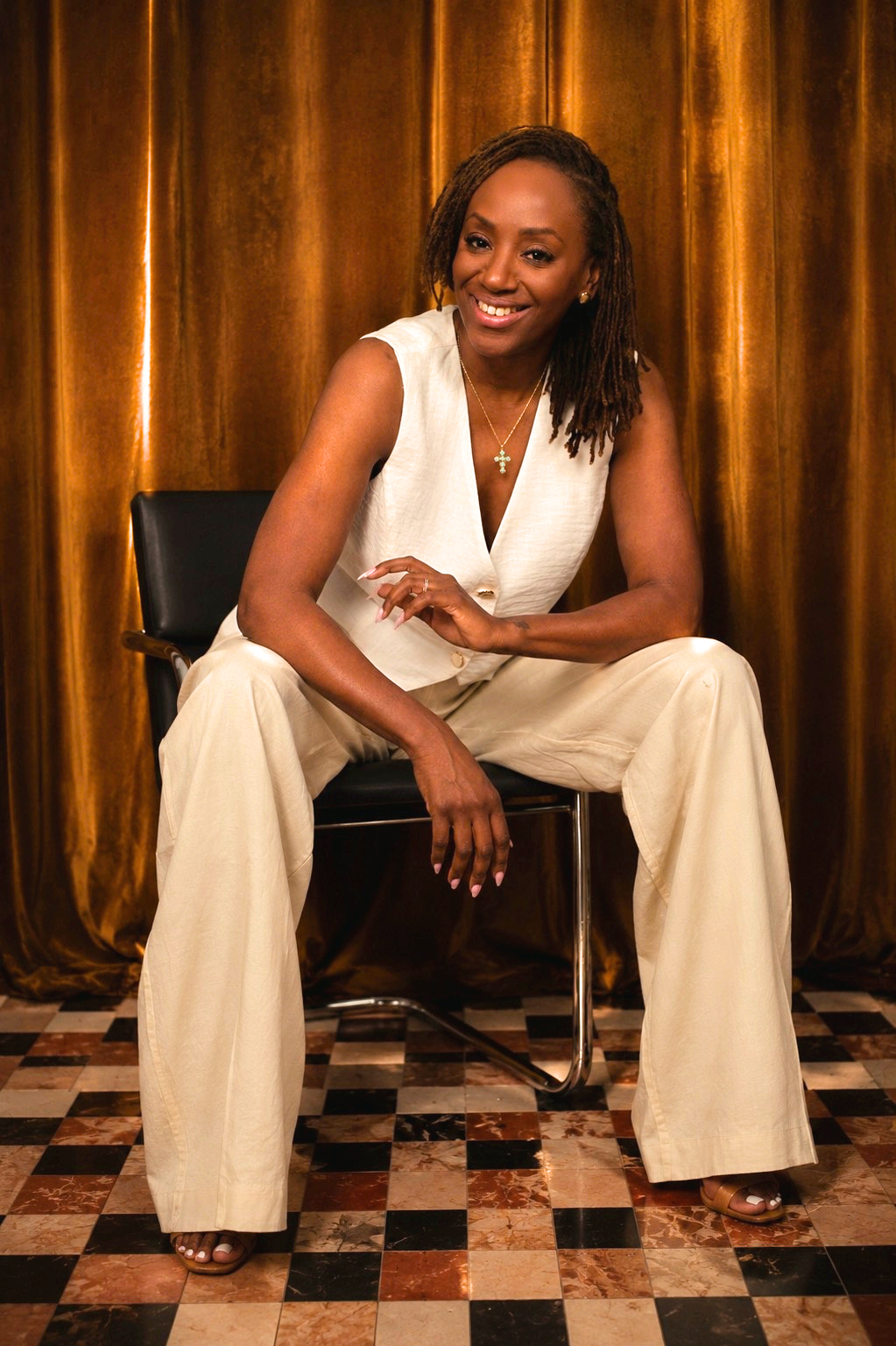 Alisa Latty-Alleyne seated in a cream suit